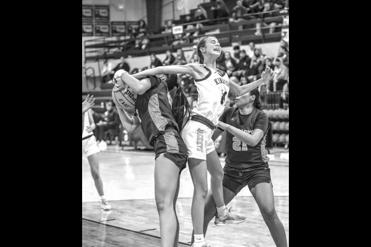 KHS FRESHMAN Ela Hartman fights for a rebound with a pair of Anadarko players during the Lady Jackets’ 38-34 loss at home last Friday. [Photo by Chris Simon/www.simon-sports-photos. smugmug.com]