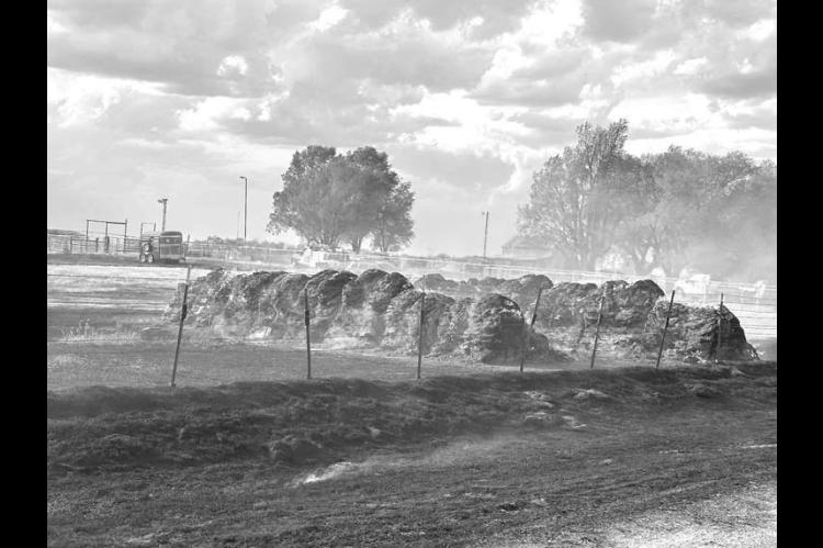 HAY FIRE – Hennessey fi refi ghters successfully work to keep fl ames away from the Heather Hawk home at about 4:30 p.m. Saturday. The family farm is located one mile south of Lacey and one mile east. The fi re was caused due to blown fuses on OG&E lines after a trackhoe two miles away hit a power line, according to Hennessey Fire Chief Brandon Scott. The fi re burned about 15 acres of farm land and 22 hay bales. [Photos courtesy of Heather Hawk]