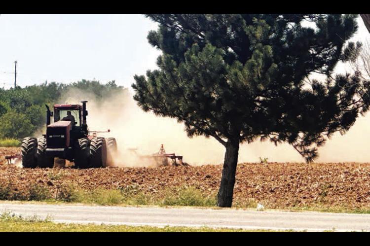 DRIED UP – At the beginning of July, a lot of county fields were too wet for combines and tractors. By the end of the month, which saw little rainfall and rising temperatures as high as 106 in Kingfisher, tractors were kicking up their share of dust in 