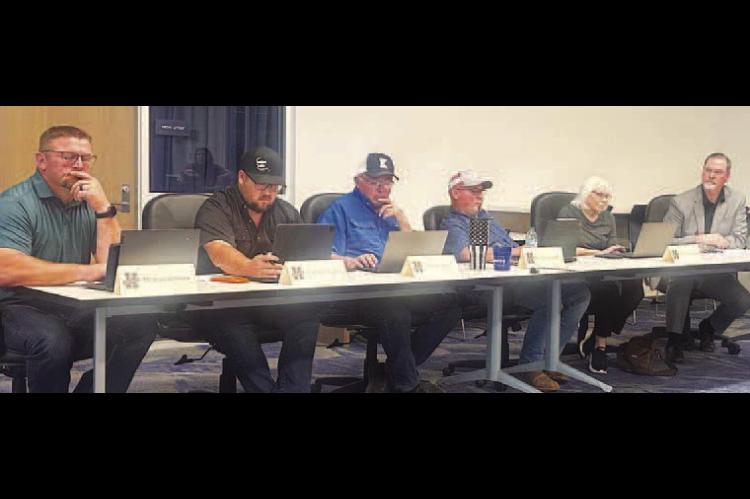 INTERIM SUPERINTENDENT Sean McDaniel, far right, looks on as Kingfisher Board of Education members look over some information during last Tuesday’s meeting. Seated at the table are, from left, Brad Wittrock, Alberto Sanchez, Bill Reitz, Charles Walker and Dana Golbek. [KT&amp;FP Staff Photo]