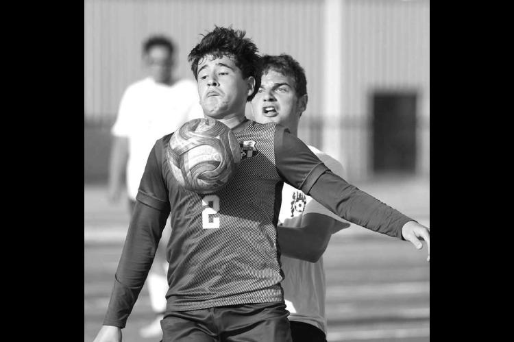 KINGFISHER’S Chris Orozco (2) holds off an Alva player while trying to control the ball during Wednesday’s 9-1 win for the Jackets on homecoming and senior night. [KT&amp;FP Staff Photo]