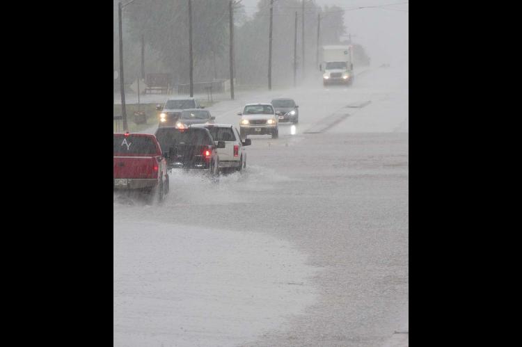 WHAT IS THAT STUFF? An unexpected deluge brought out our cameras Monday, if only to document that rain actually does fall in August – occasionally. The fast, heavy rainfall caused brief and localized flash flooding on North Main Street. [KT&FP Staff Photo by Twila Adams]