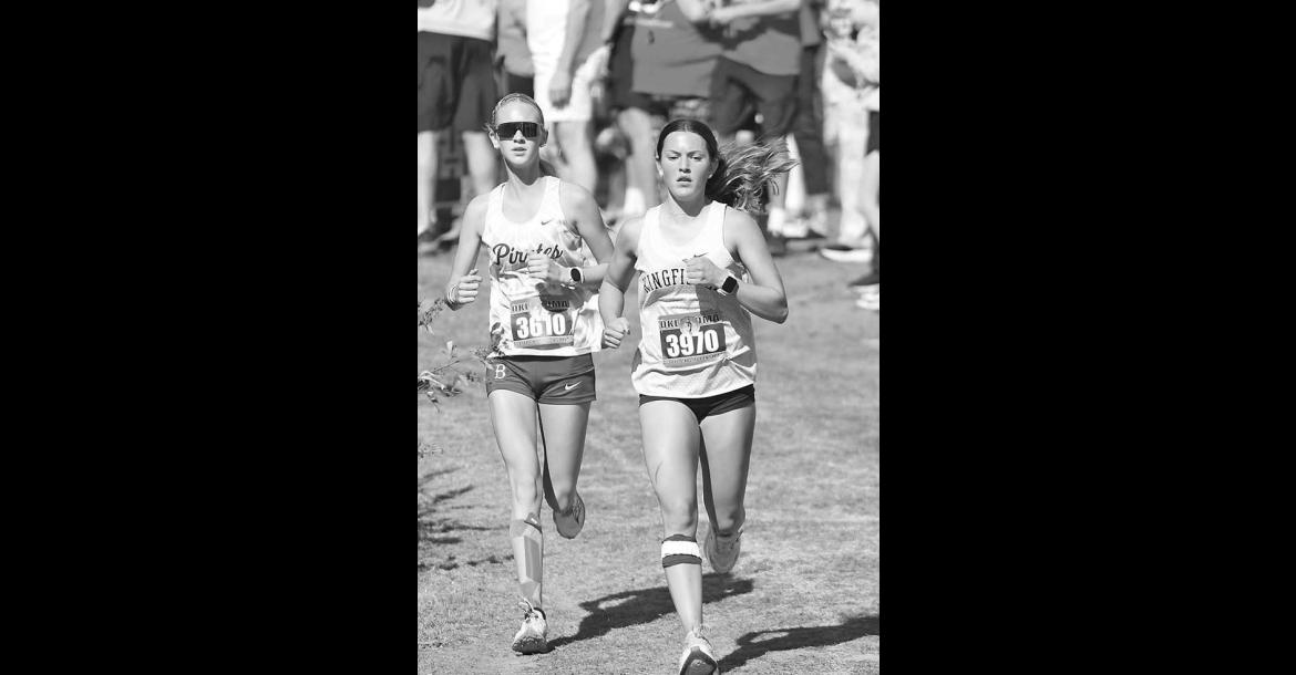 KHS SENIOR Mattie Slezickey (right) makes her way down a decline just beyond the mid-point of Saturday’s Class 4A state cross country meet. [KT&amp;FP Staff Photo]