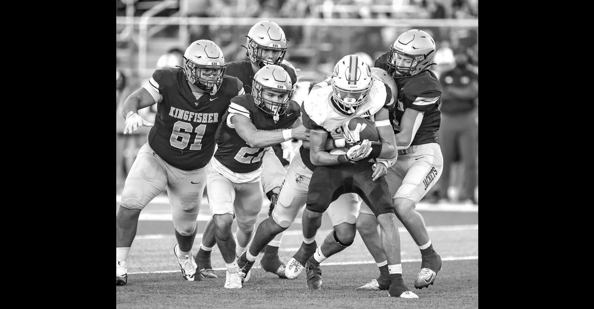 KINGFISHER DEFENDERS, from left, Donovan Dunn, Jayzen Surveyor, Eduardo De La Torre (behind ball carrier) and Camden Weinmeister swarm to the ball during the first half. Pictured on the left is senior Carter Stephenson going up for one of his three catches on the night, which totaled 90 yards. On the right is Drew Snider powering through the grasp of Clinton’s Parker Turney as he scored on a 37-yard touchdown run in the first quarter. [Photos by Chris Simon/www.simon-sports-photos.smugmug.com]