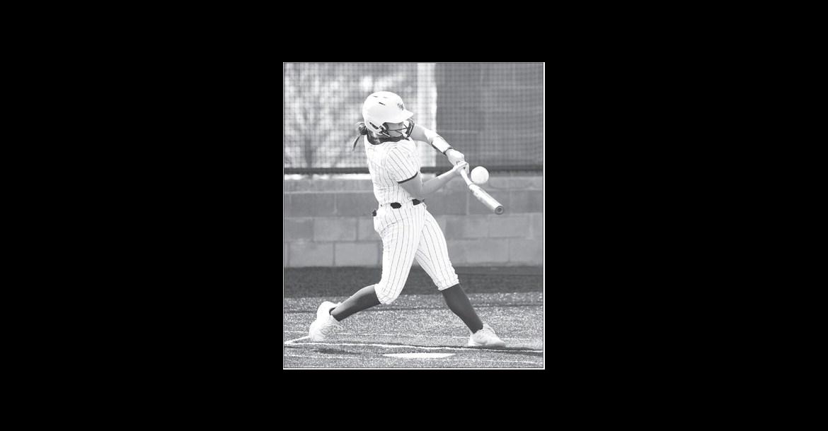 KHS SENIOR Kinlee East (above) puts a little bend in her bat during a plate appearance Thursday against Woodward. She delivered 2 RBIs, inluding the one to put KHS up for good. Junior Lily Voth (right) throws out a runner while on one knee from her shortstop position. East and Voth also combined to pitch the seven-inning victory against the Boomers. [KT&FP Staff Photos]
