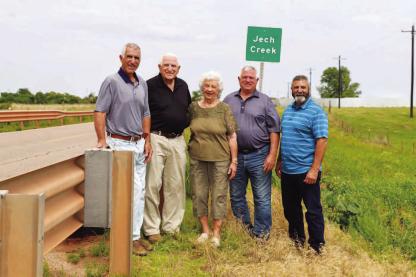 JECHS AT JECH CREEK – Arnold and Donna Jech (second and third from left) stand near the sign on State Highway 33 east of Kingfisher that signifies the crossing of Jech Creek. Arnold started a quest in the 1970s to have the creek named in his parents’ honor. Pictured with them are their sons, from left: Danny, Jerry and Ronny Jech. [Photo provided]