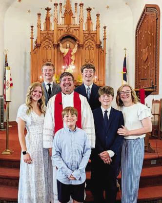 STARK FAMILY – Clint Stark is the new pastor at St. John’s Lutheran Church in Okarche. The Stark family has recently moved to Okarche from Texas. Pictured with Clint and his wife Brianne (far right) at the church are their son Benjamin (front row), daughter Mary (far left) and sons Simeon (middle row), Henry and Wyatt (back row). [Photo provided]