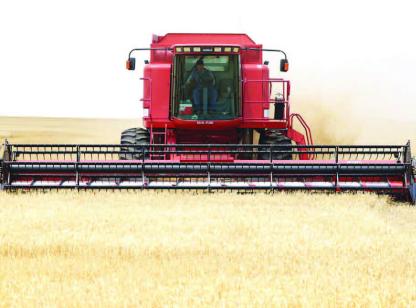 COMBINES were in the fields throughout southern portions of Kingfisher County early in the week, such as this one operated by Kenneth Karrenbrock west of Kingfisher on Monday afternoon. Early-morning showers on Tuesday put a temporary halt to the cutting that had begun. [KT&amp;FP Staff Photo]