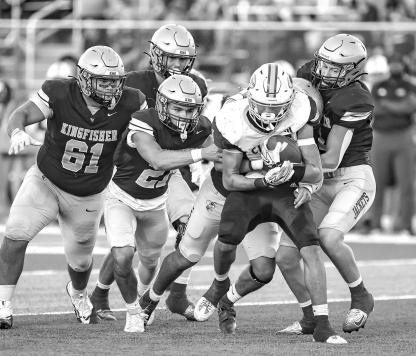 KINGFISHER DEFENDERS, from left, Donovan Dunn, Jayzen Surveyor, Eduardo De La Torre (behind ball carrier) and Camden Weinmeister swarm to the ball during the first half. Pictured on the left is senior Carter Stephenson going up for one of his three catches on the night, which totaled 90 yards. On the right is Drew Snider powering through the grasp of Clinton’s Parker Turney as he scored on a 37-yard touchdown run in the first quarter. [Photos by Chris Simon/www.simon-sports-photos.smugmug.com]