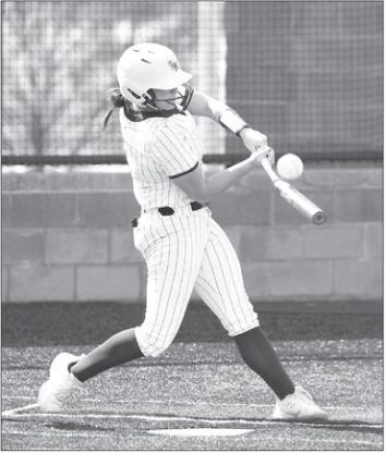 KHS SENIOR Kinlee East (above) puts a little bend in her bat during a plate appearance Thursday against Woodward. She delivered 2 RBIs, inluding the one to put KHS up for good. Junior Lily Voth (right) throws out a runner while on one knee from her shortstop position. East and Voth also combined to pitch the seven-inning victory against the Boomers. [KT&FP Staff Photos]